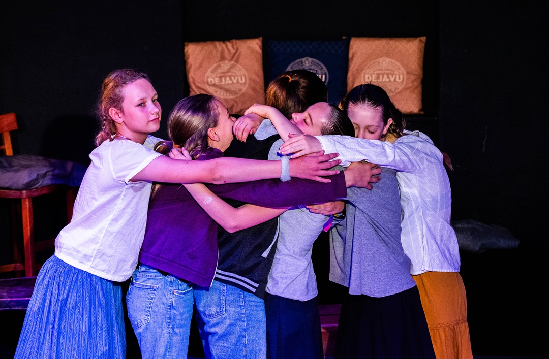 Sechs Jugendliche halten sich gegenseitig fest in einer Umarmung, Szene aus Theaterstück.