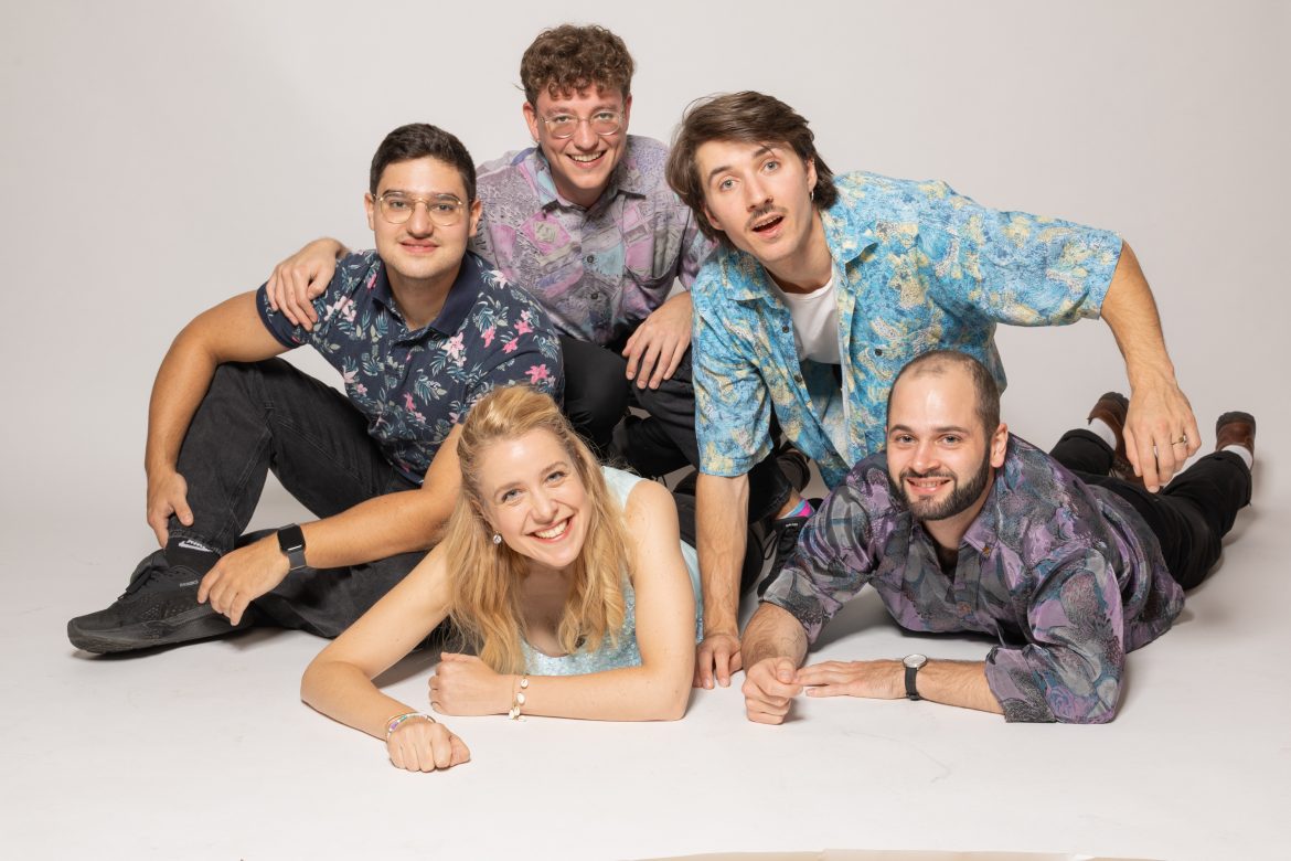 Gruppenfoto der Band "Five Flying Elephants": Vier Musiker und eine Musikerin lächeln freundlich in die Kamera.