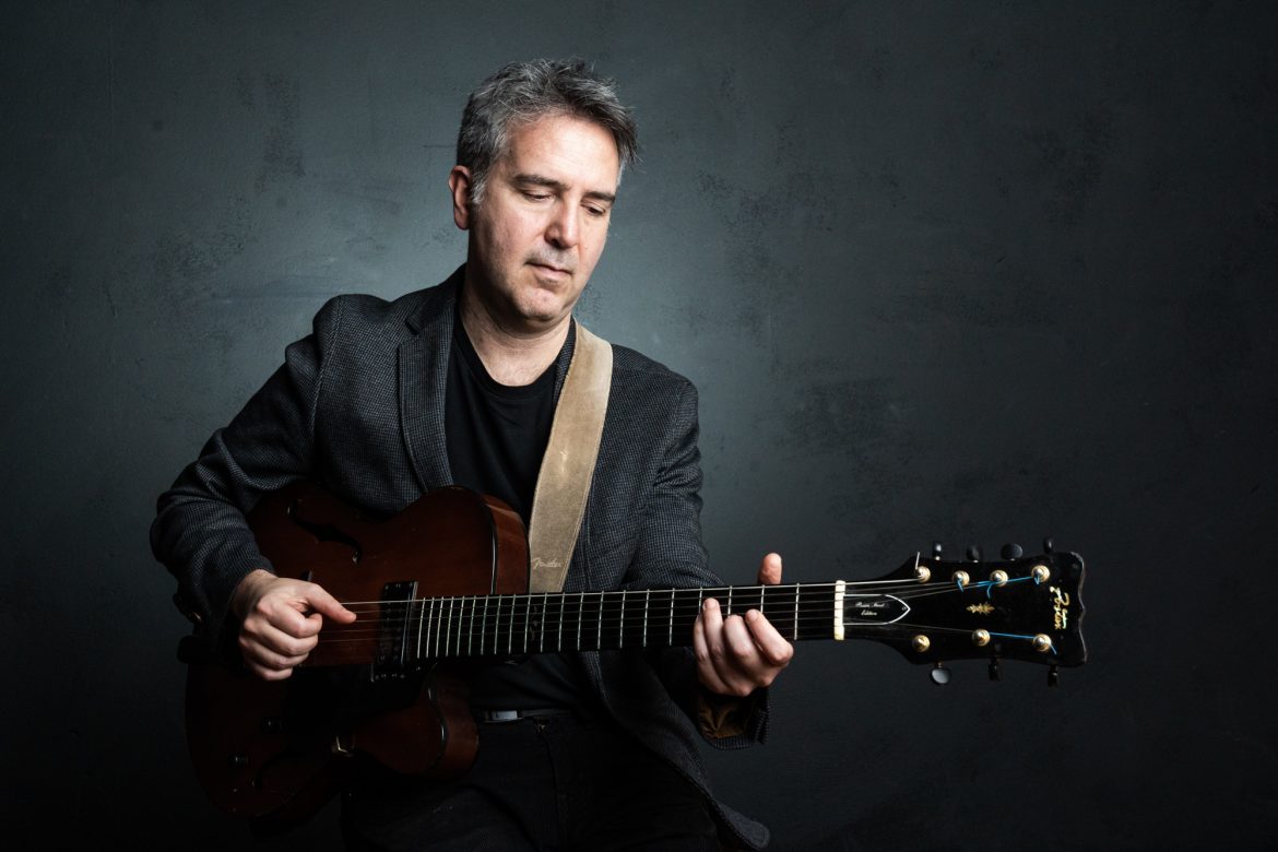 Das Foto zeigt Hugo Fernandez beim Gitarrenspiel.