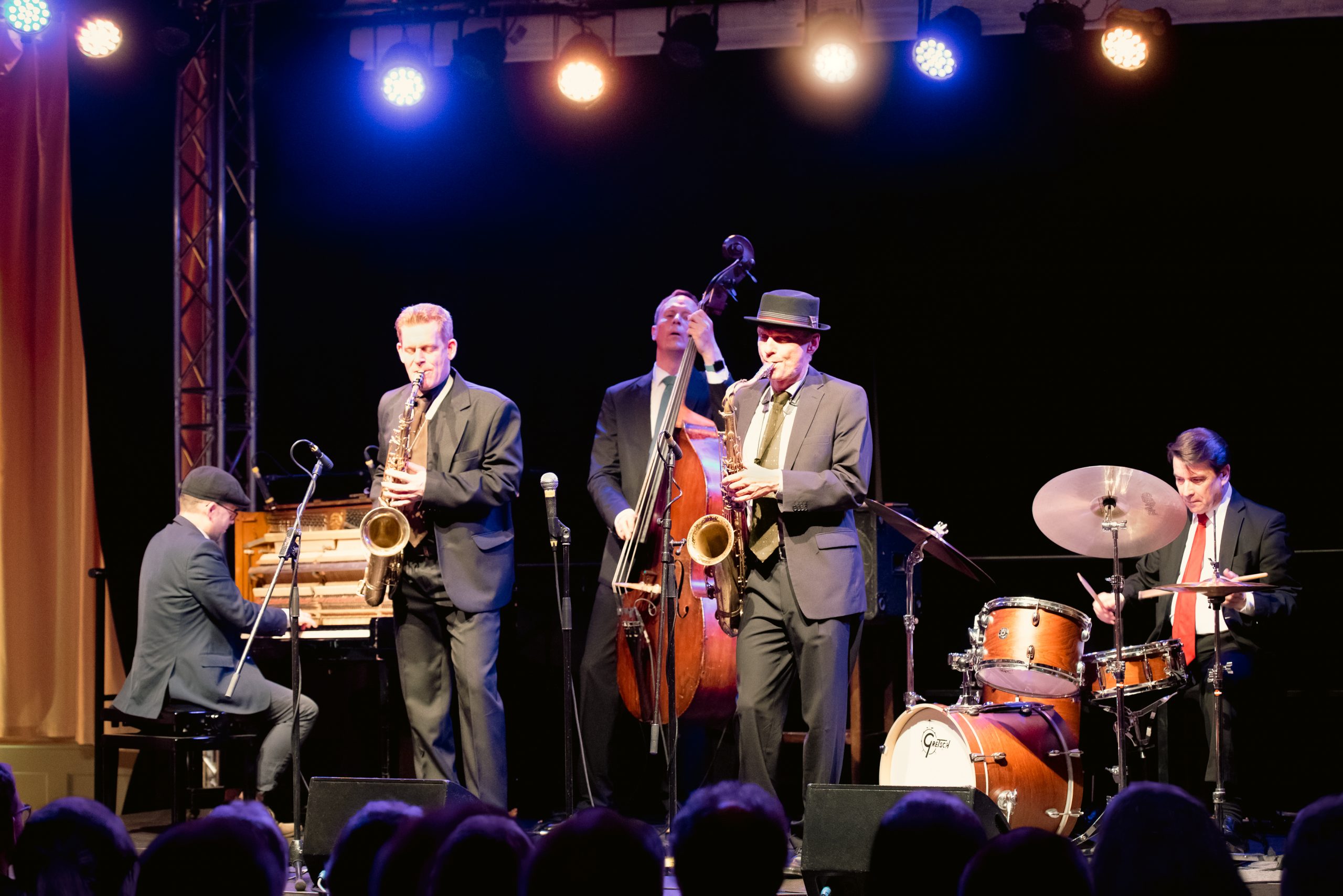 fünf Musiker mit Instrumenten auf der Bühne.