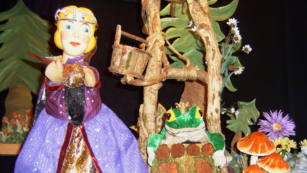 Szene aus dem Märchen "Der Froschkönig", dagestellt mit Puppen: Die Prinzessin mit der goldenen Kugel am Brunnen