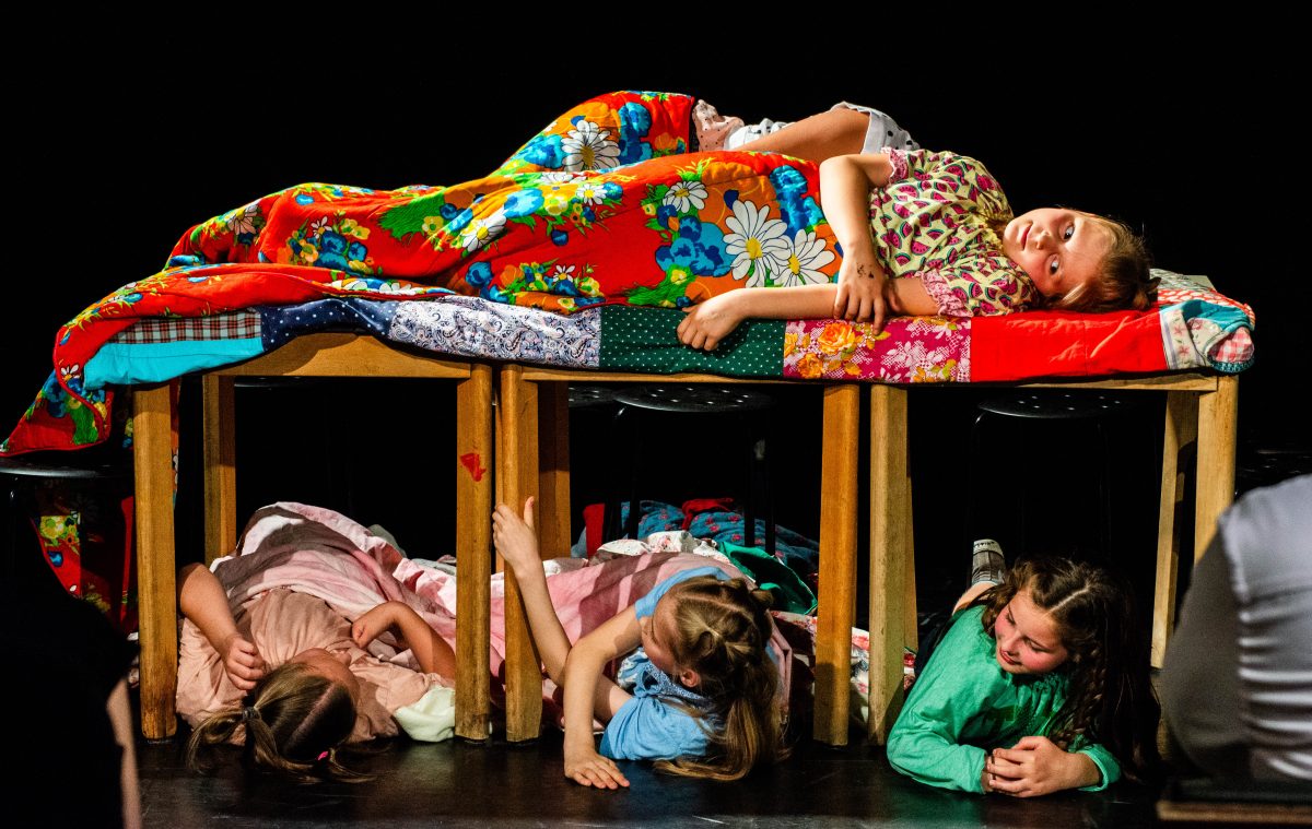 Vier Kinderschauspielerinnen auf der Bühne in einer Art Schlafsaal.